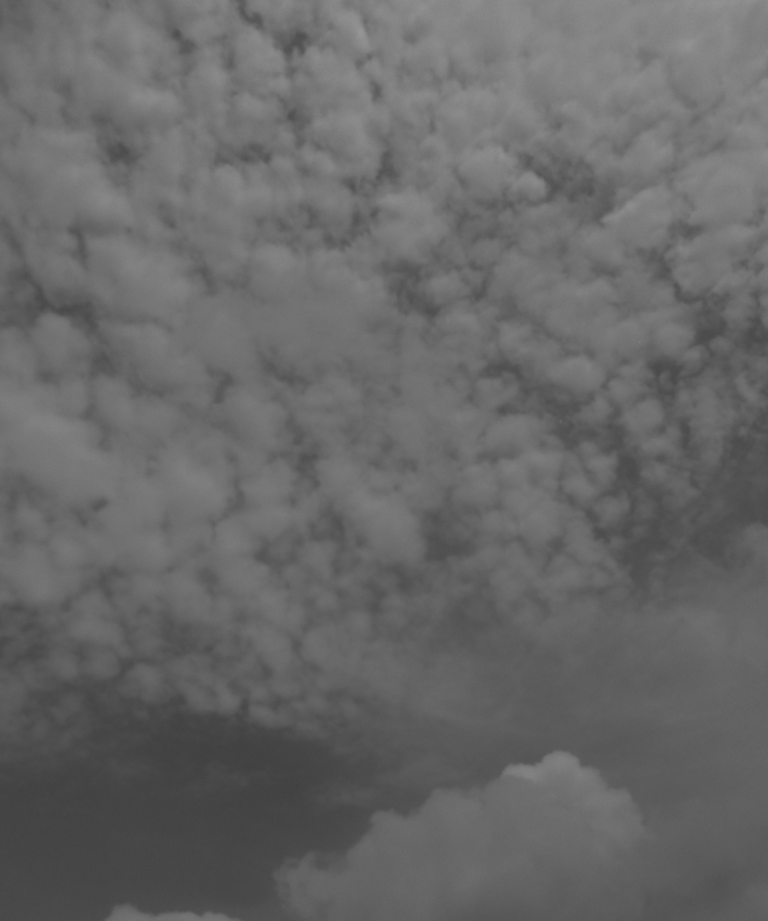 Cielo cubierto de nubes texturizadas en blanco y negro.