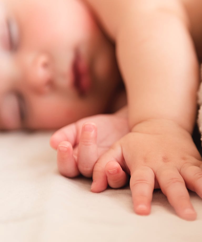 a baby is laying on a bed with a blanket