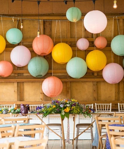 a wedding reception table with paper lanterns