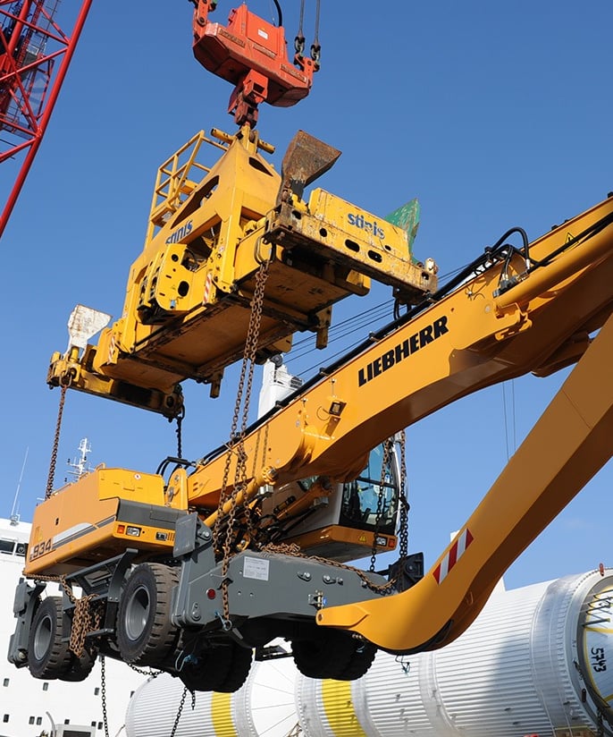 a crane crane is lifting a large container