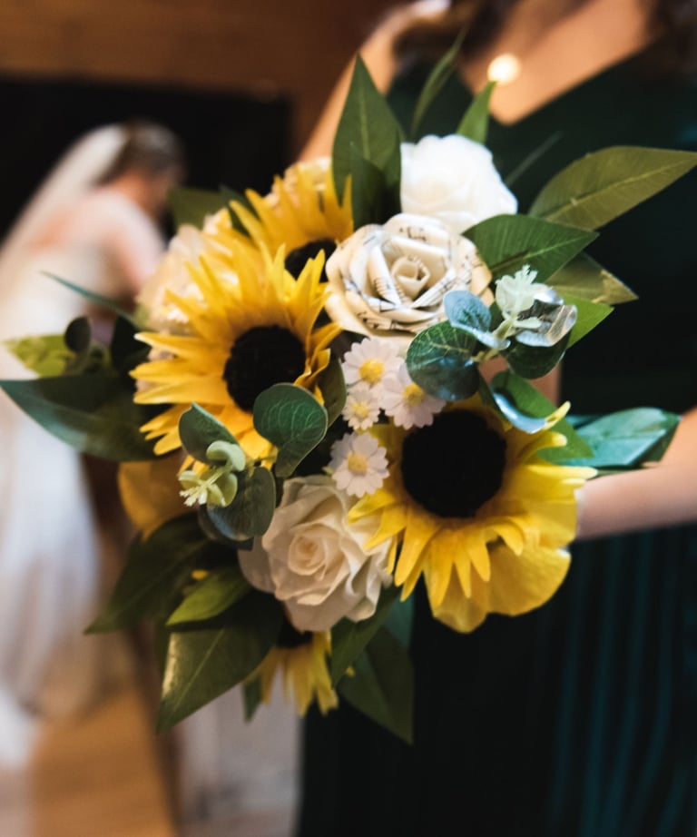 a woman in a green dress holding a bouquet of wedding flowers