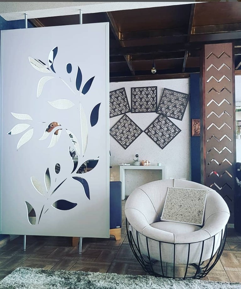 Ambiente moderno com divisória decorativa tipo cobogó em padrão de folhas e espelhos, integrando estilo e funcionalidade na s