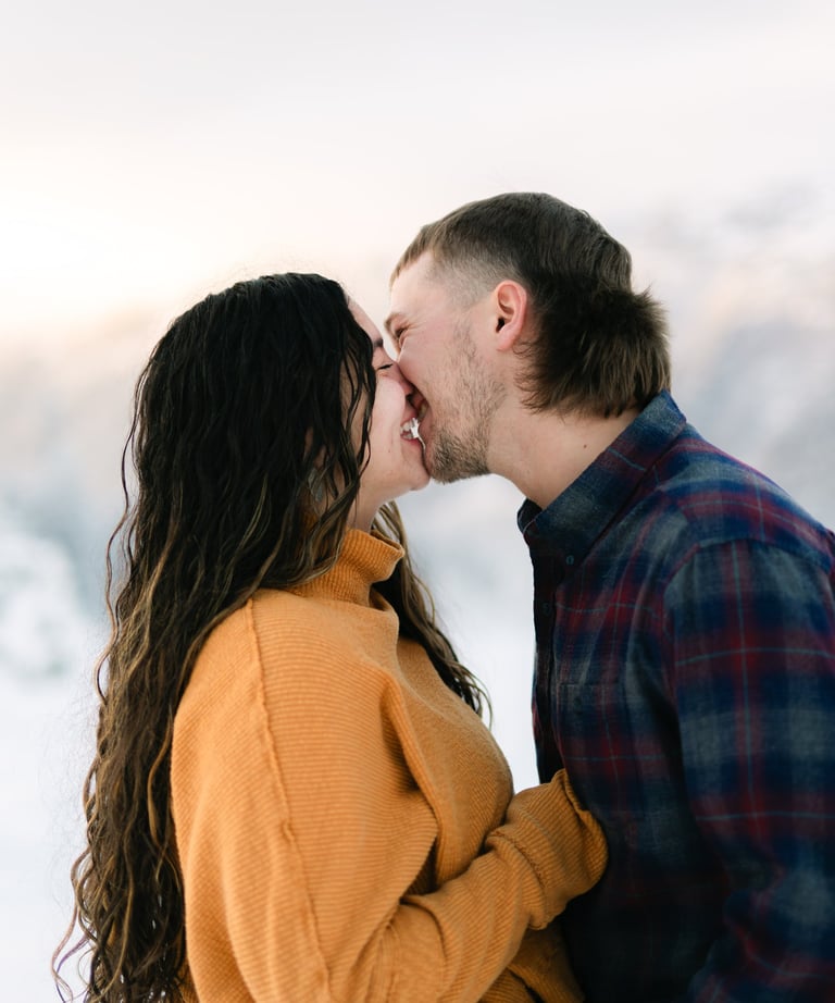 a man and woman kissing in the snow