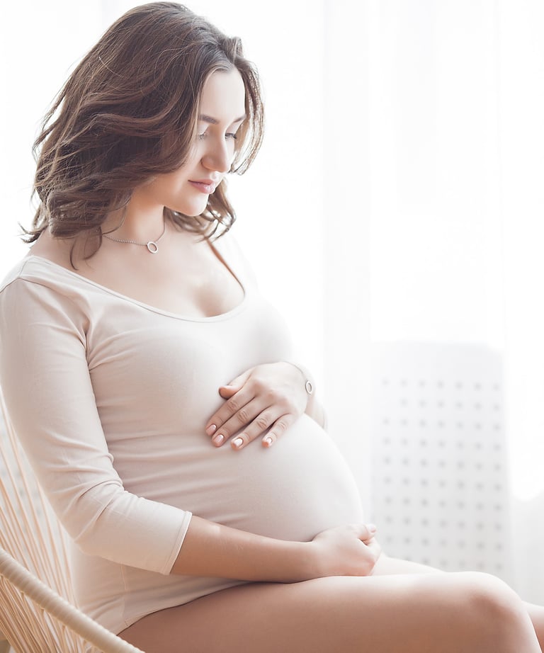 a pregnant woman sitting in a chair holding her belly