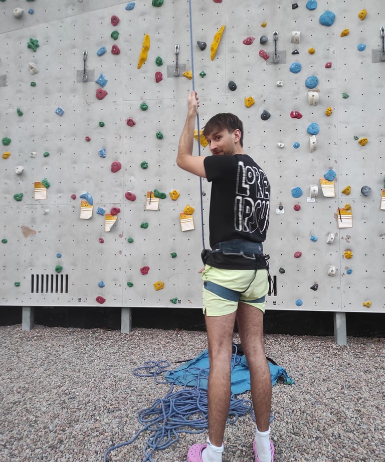 Ole beim Sichern beim Seilklettern in pinken Adiletten.