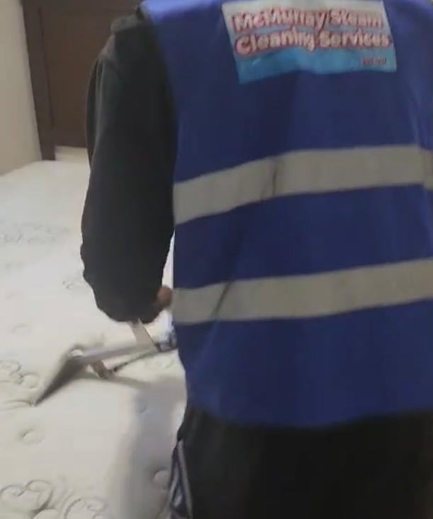 Technician steam cleaning bed in Fort McMurray home.