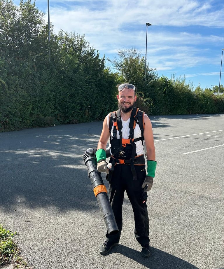 a man in a vest and a backpacker in a parking lot