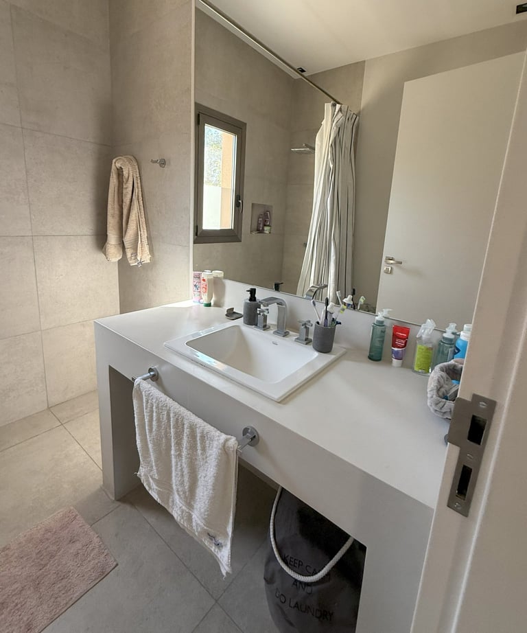 a bathroom with a sink and a bucket with soap