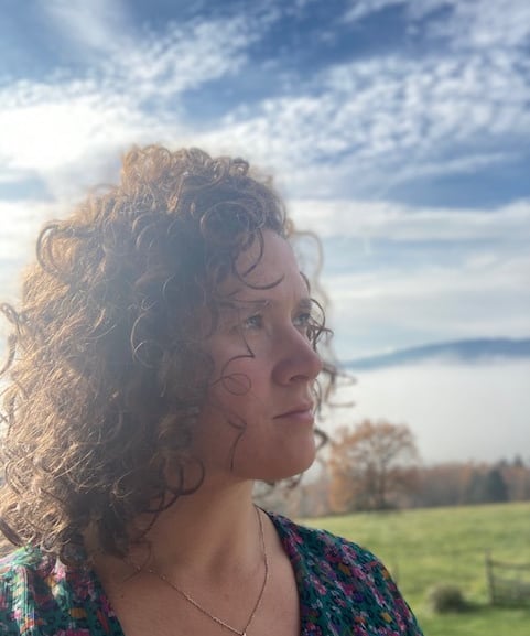 Portrait d'une Architecte d'interieur avec des cheveux frisée et un regard bleu lointain 