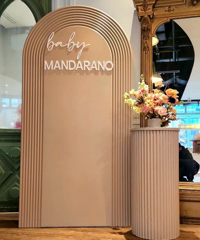 Baby shower with a sign that says, baby mandarino, and a vase with flowers in it