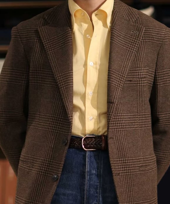 a man in a suit and tie dyes a yellow shirt