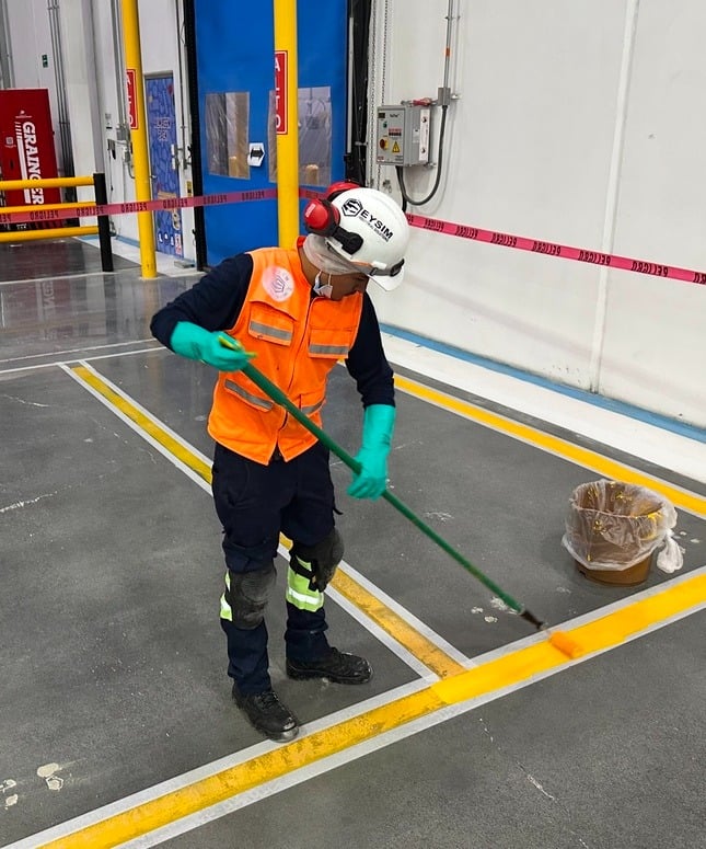 un hombre pintando unas líneas para delimitar un área