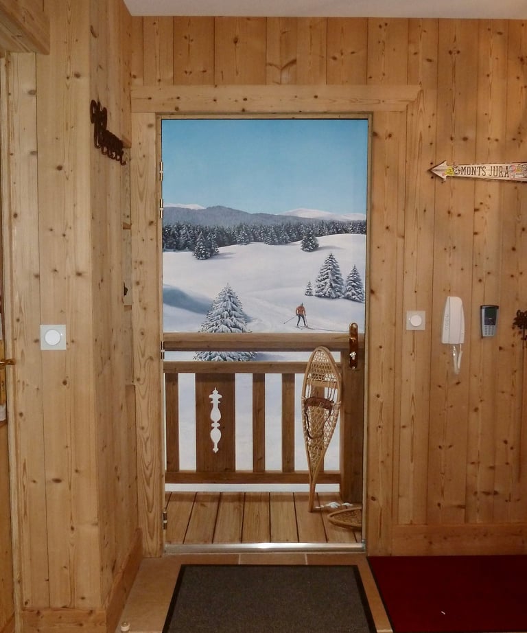 Trompe-l'oeil réalisé sur une porte d'entrée. Il représente un paysage enneigé avec barrière en bois