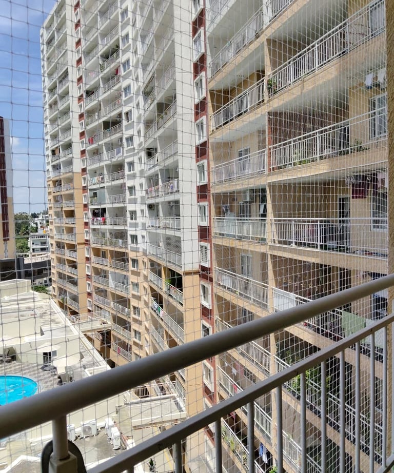Technician from Sukumari Safety Nets fitting a pigeon net over a window frame.