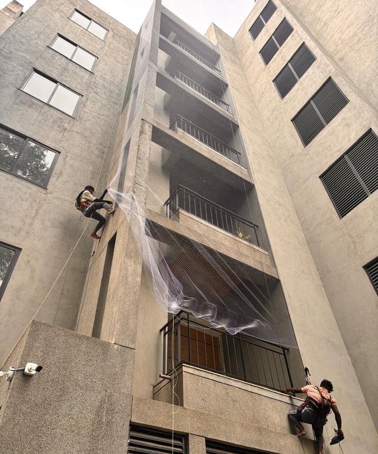 Technician from Arjilli Enterprises fitting a pigeon net on a residential balcony in Chennai.