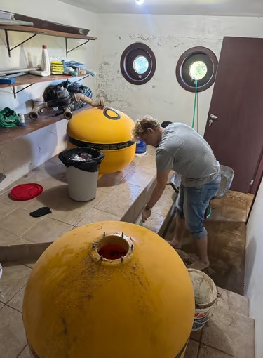 Um técnico realizando manutenção de piscina em um sistema de filtro de areia amarela em uma despensa