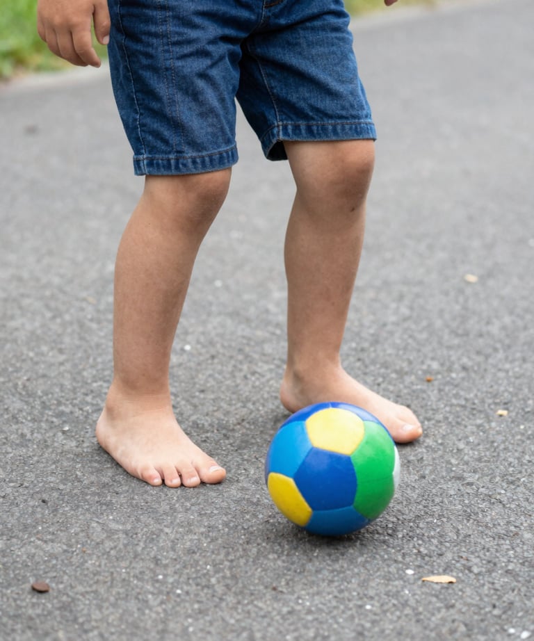 Close-up of a young boy smiling proudly in his football uniform during practice.