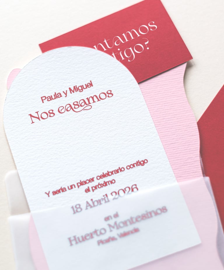 Papeles de diferentes colores y formas que parecen pertenecer a una invitación de boda
