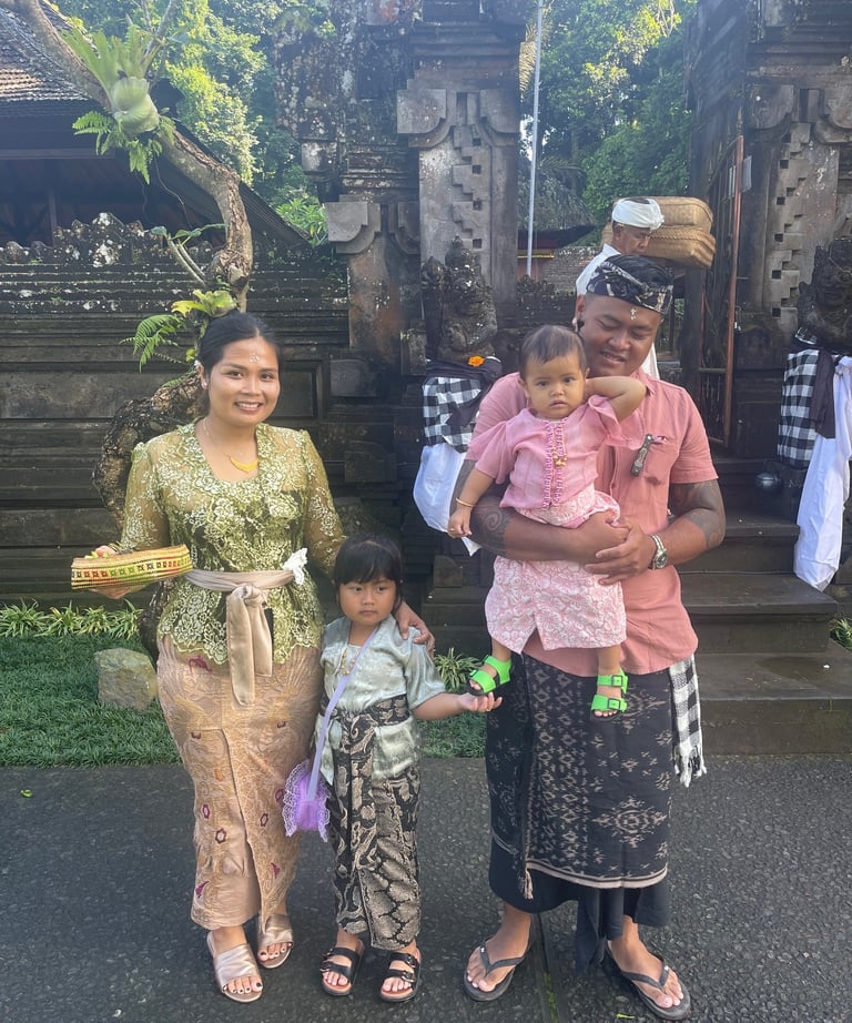 Famille balinaise en tenue traditionnelle devant un temple lors des célébrations.