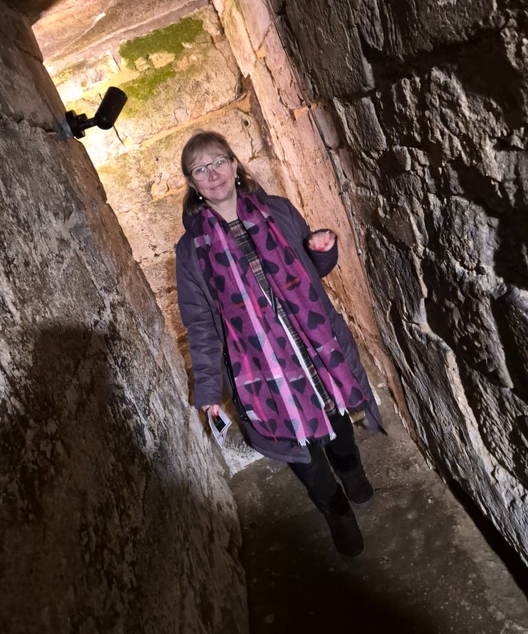 Penelope Jane wandering through a narrow stone passage in the crypt beneath Hexham Abbey