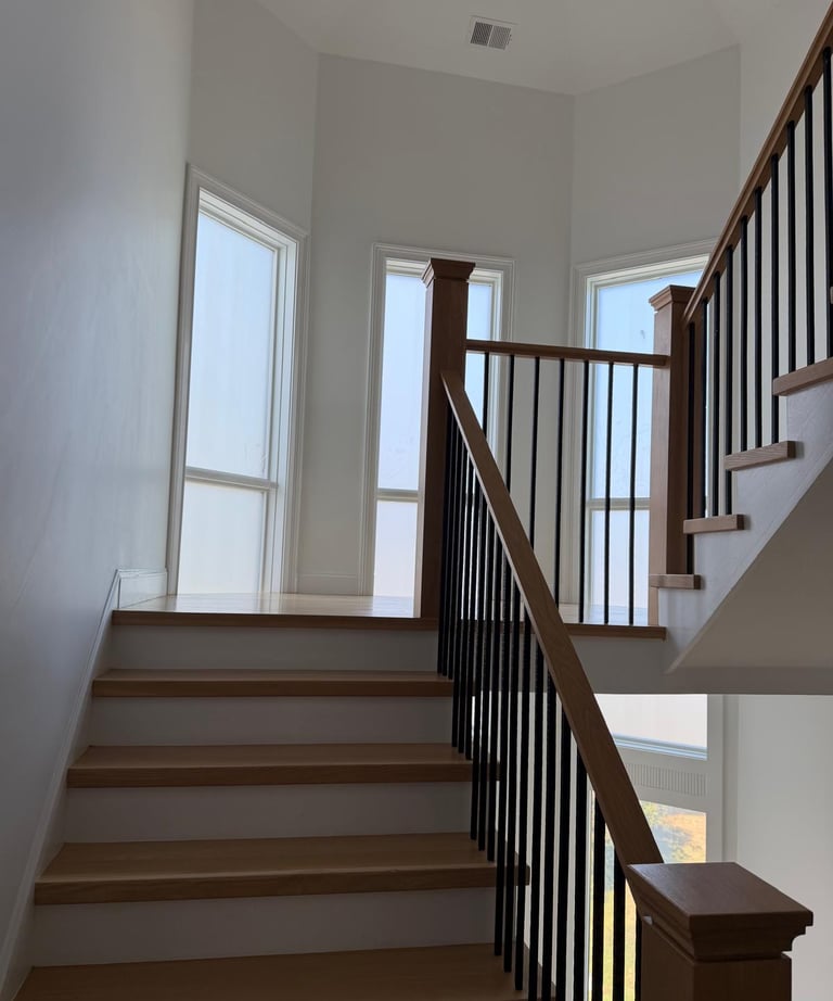 Interior staircase with glass railing and natural light