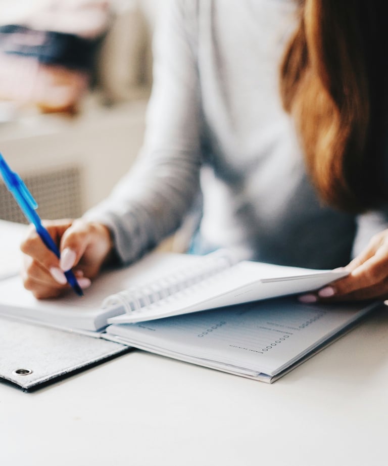 Woman is writing something on a notebook