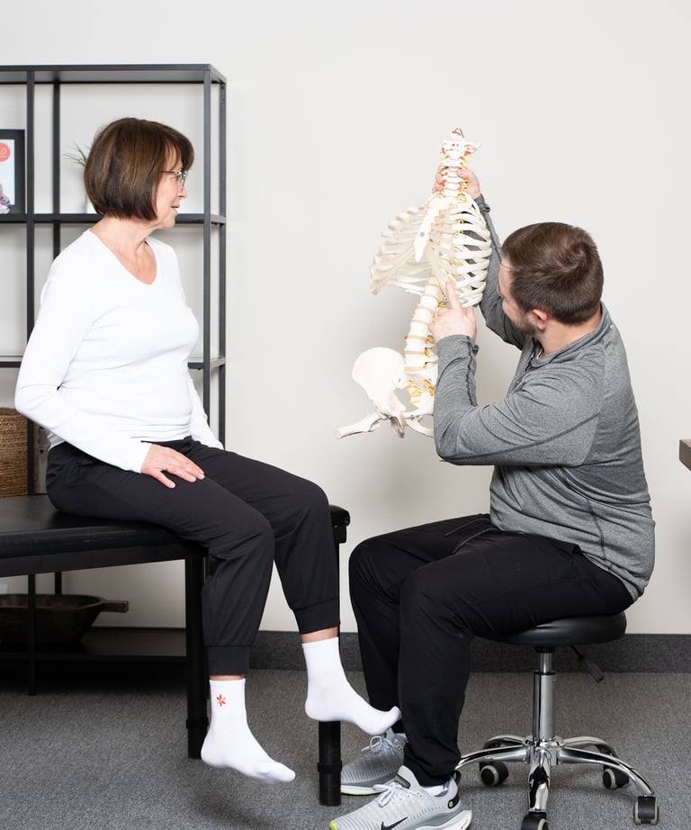 Practitioner illustrating on a model spine to the patient at JD Osteopathy Mississauga