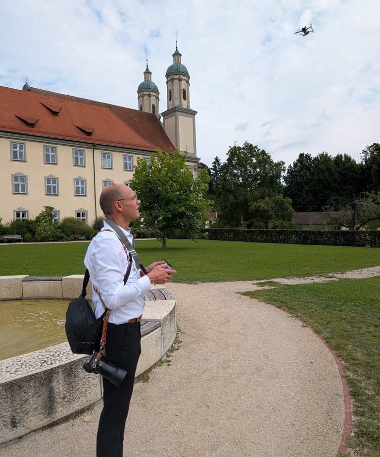 a man standing in front of a building and flying a drone dji