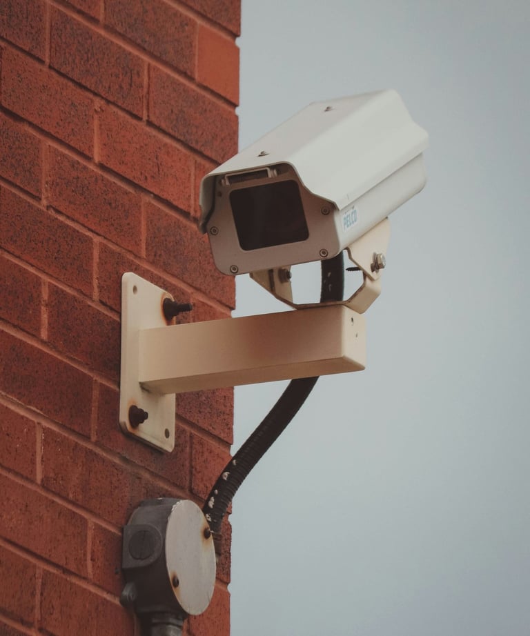 a camera mounted to a brick wall near a brick wall