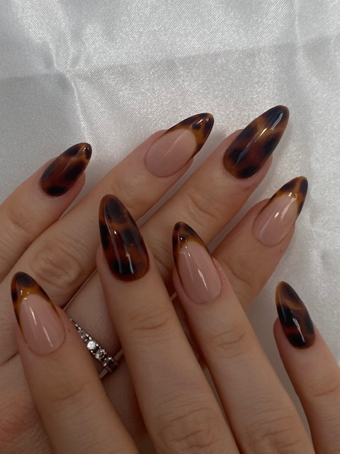 a woman's hand painted nails with a leopard print