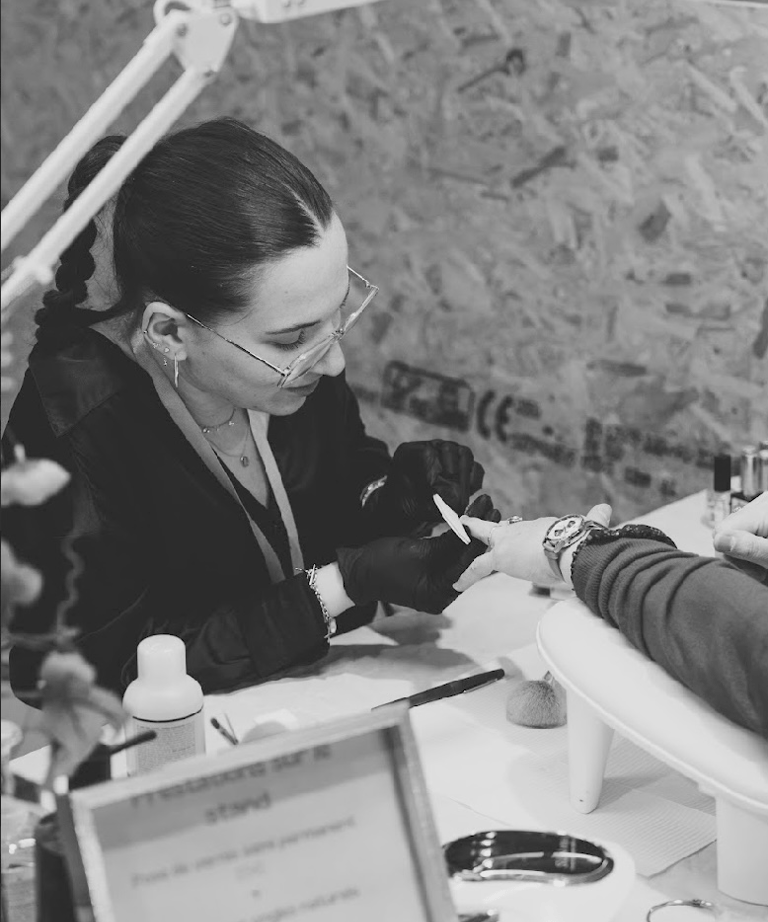 a woman getting her nails done by a professional nail technician