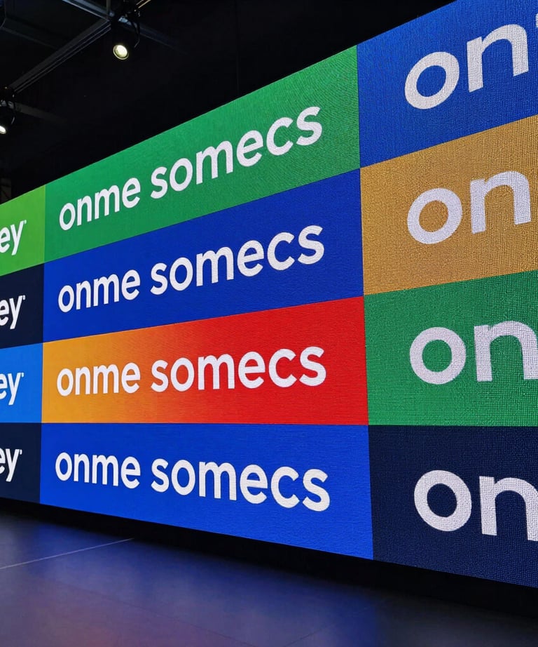 A wide shot of a multi-screen LED video wall display at a corporate launch event in a North American venue, vibrant colors and sharp text.