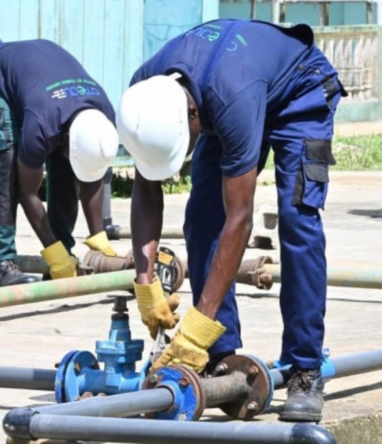 Plombiers en uniformes réparant un système de canalisation d'une entreprise à Yaoundé au Cameroun