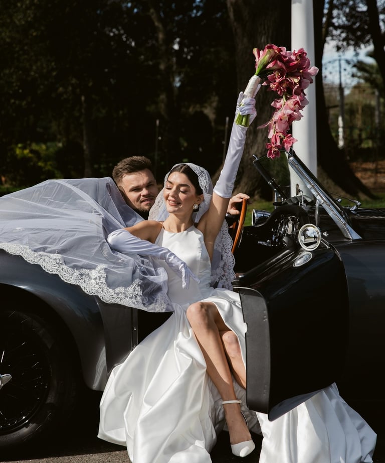 Woman and a man sitting in a 1958 MG MGA Roadster at Tulu Vineyards in Galt, Ca.