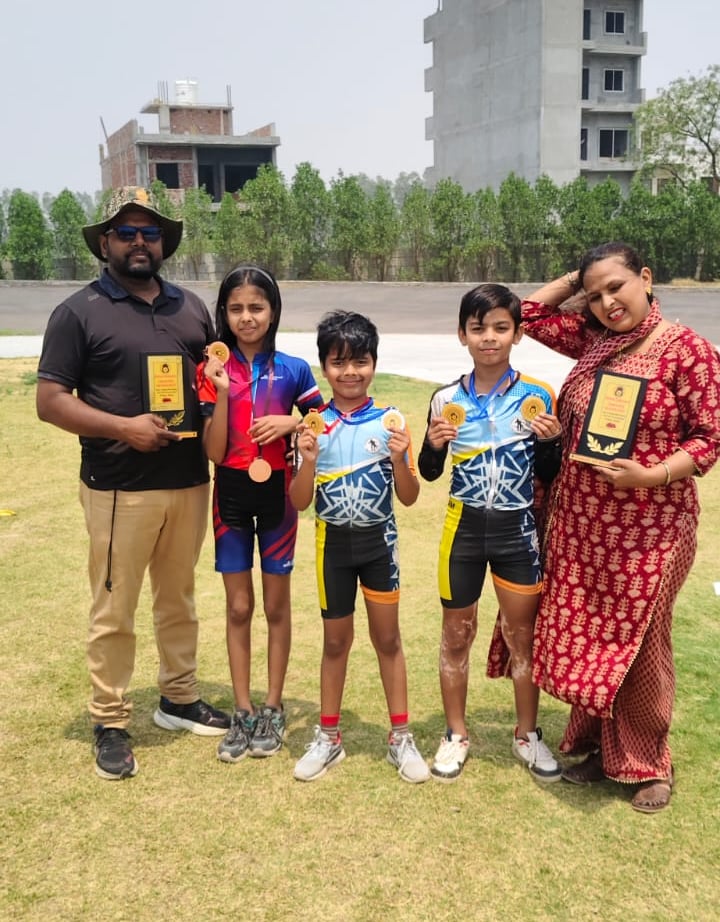 Young athletes proudly display gold medals and trophies with their coaches after a roller skating competition.