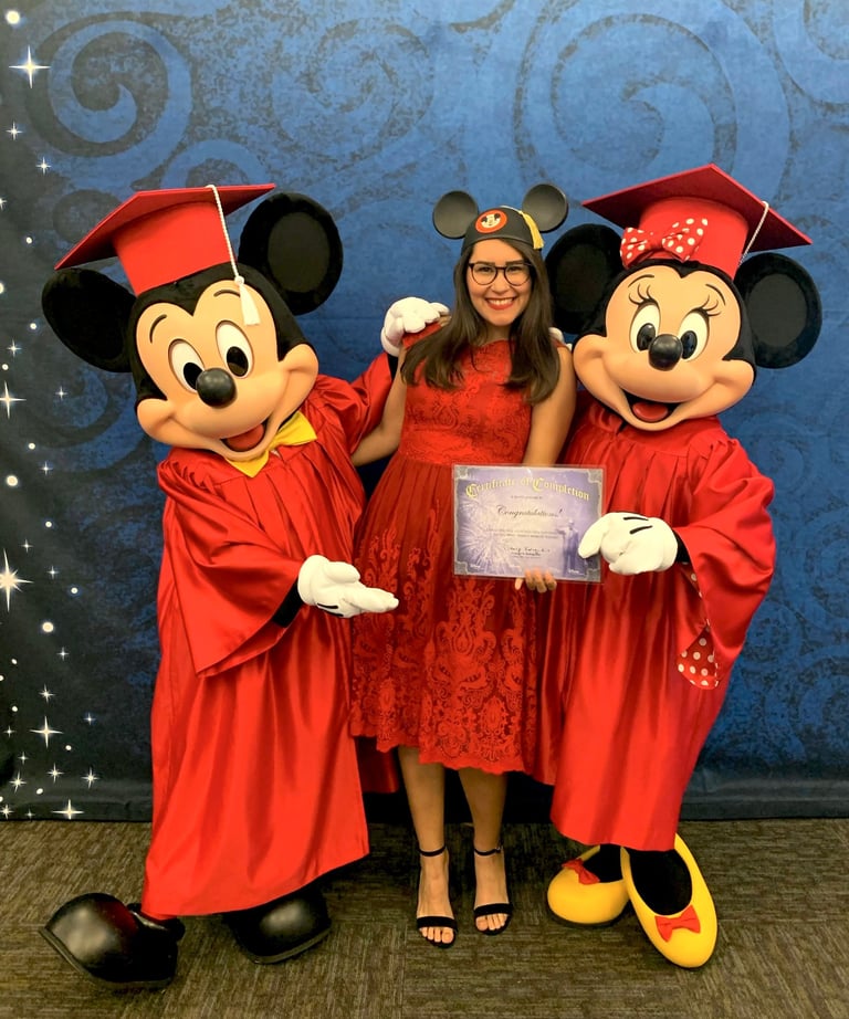 Mujer posando con Minnie y Mickey Mouse en graduación de Programa Internacional de Disney