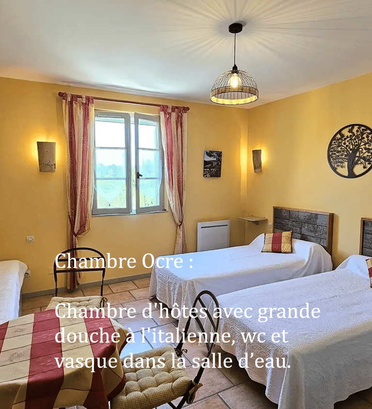 chambre Ocre de "la ramade" avec 2 lits séparés, une table et miroir rond, mur ton jaune ocre.