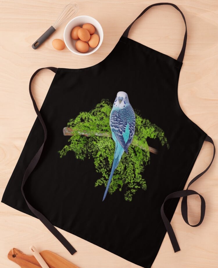 a blue parakeet bird sitting on a tree branch design on a black apron
