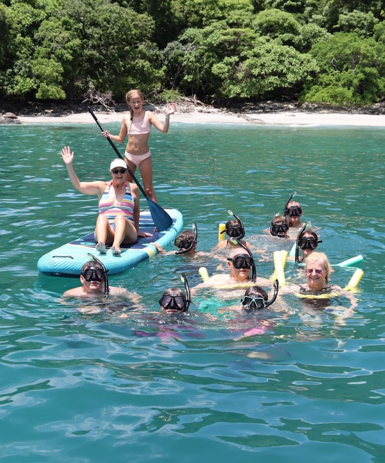Family enjoying snorkeling and paddle boards in turquoise waters during catamaran tour Papagayo