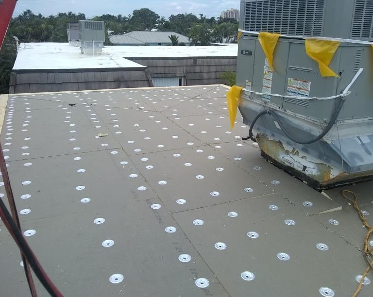 Inst of tapered insulation secured with screws and plates ready for mid plies and cap sheet