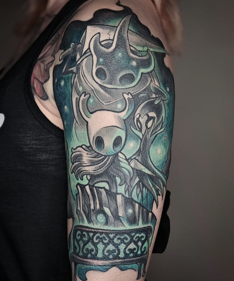 Female upper arm with Hollow Knight half sleeve tattoo.