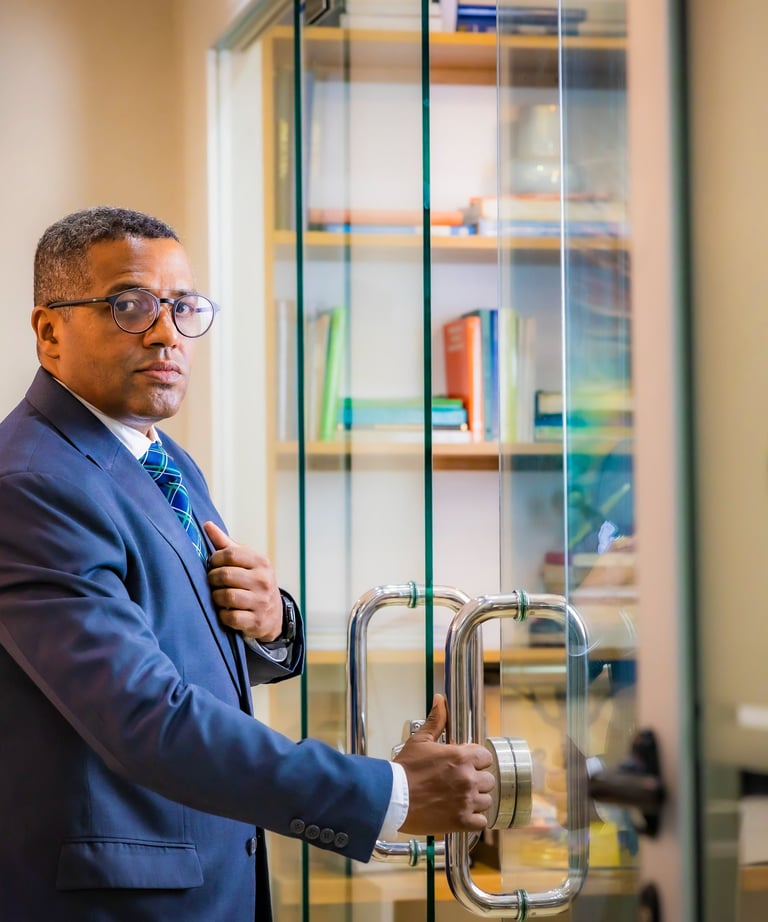 a man in a suit and tie is standing in front of a glass door