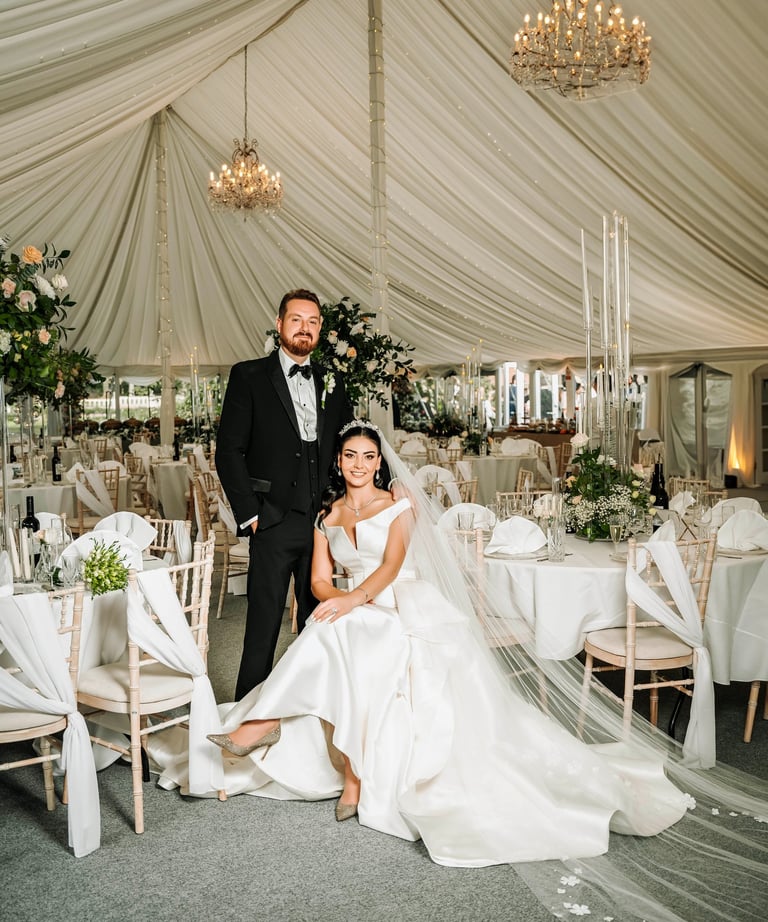 Bride and groom in an elegant white wedding marquee