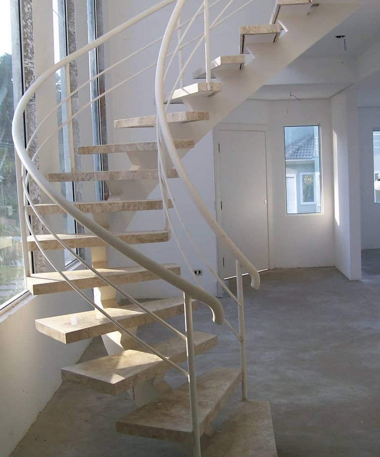 Escada interna com degraus de concreto, faixas antiderrapantes e corrimão de alumínio em ambos os lados para acessibilidade, 