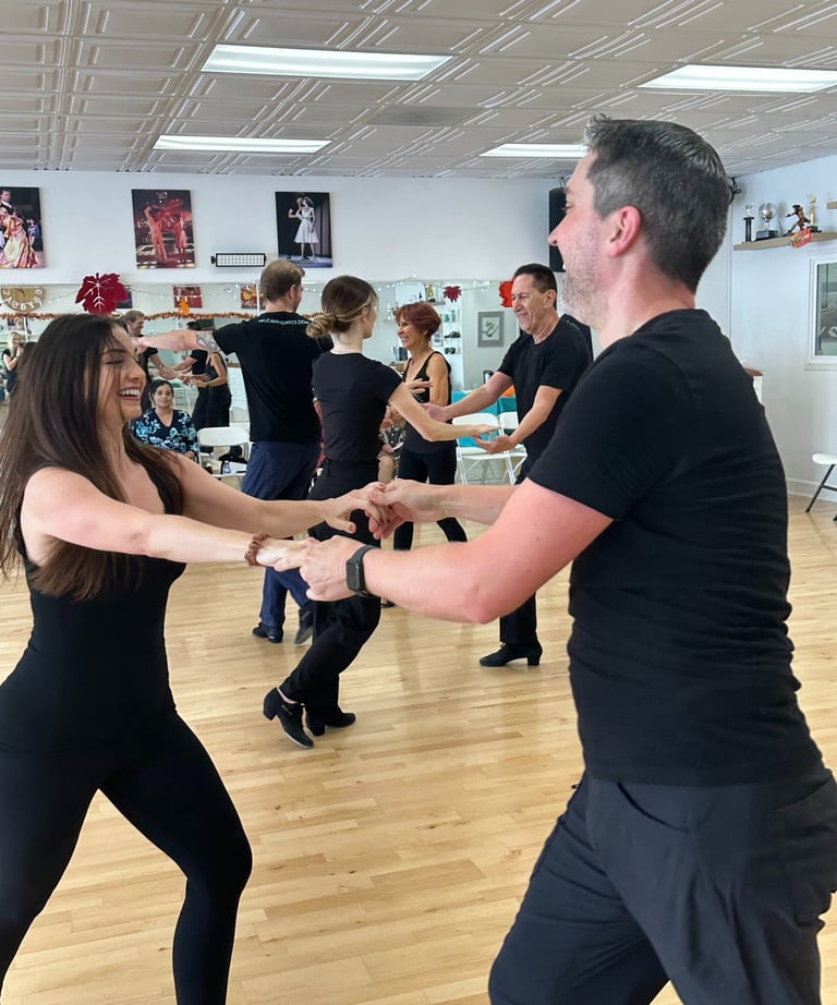 A joyful ballroom dance class at McCann Dance, where students of all levels learn social dance