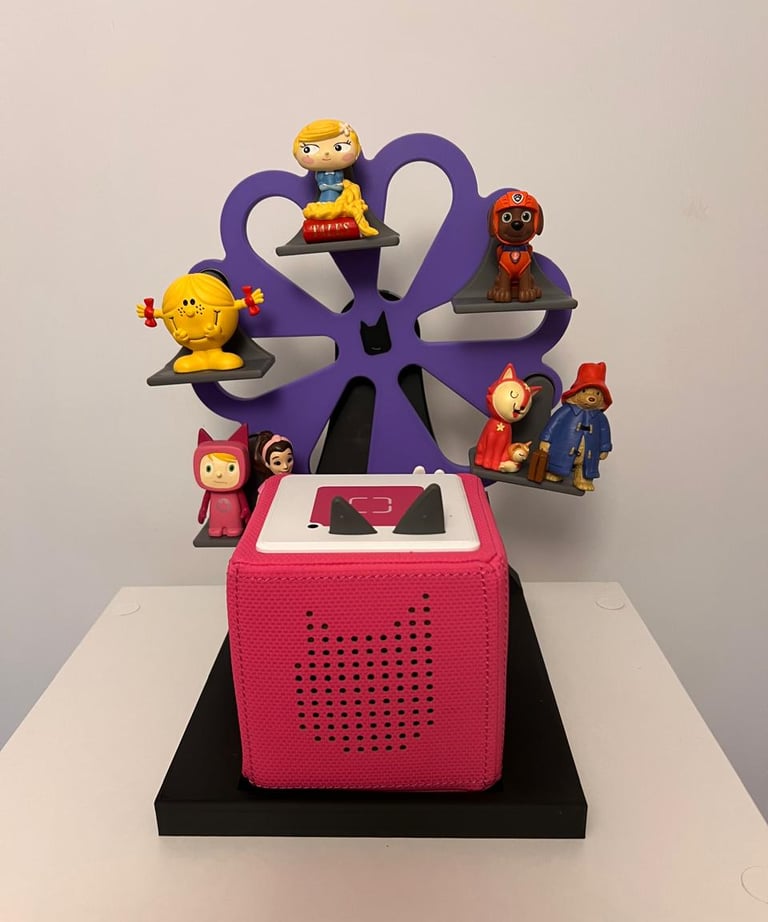 Pink Toniebox audio player with Tonies figures on a purple ferris wheel shelf.
