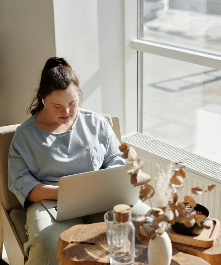 a woman sitting in a chair with a laptop computer