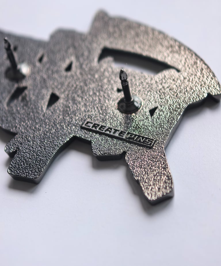 Back of a textured custom enamel pin featuring dual posts and a stamped logo for branding.