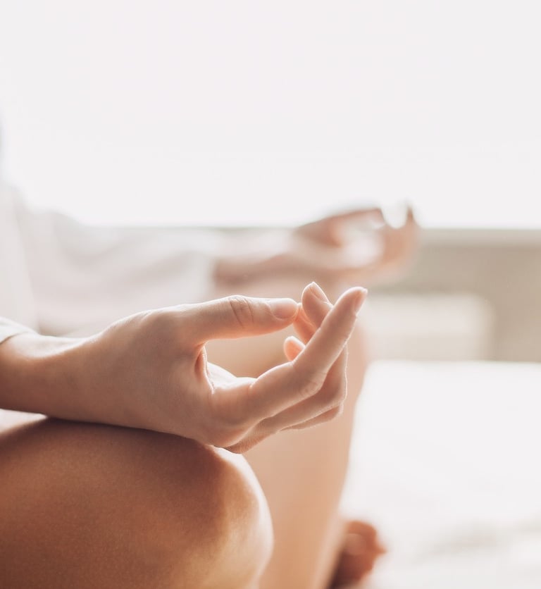 On devine une femme assise en tailleur pour une séance de méditation. 