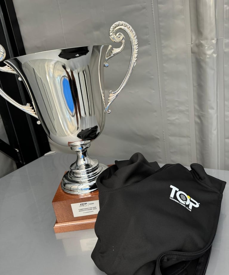 Polished silver trophy and black Torrino Padel Club vest awarded at the 2024 Italian Padel Championships.